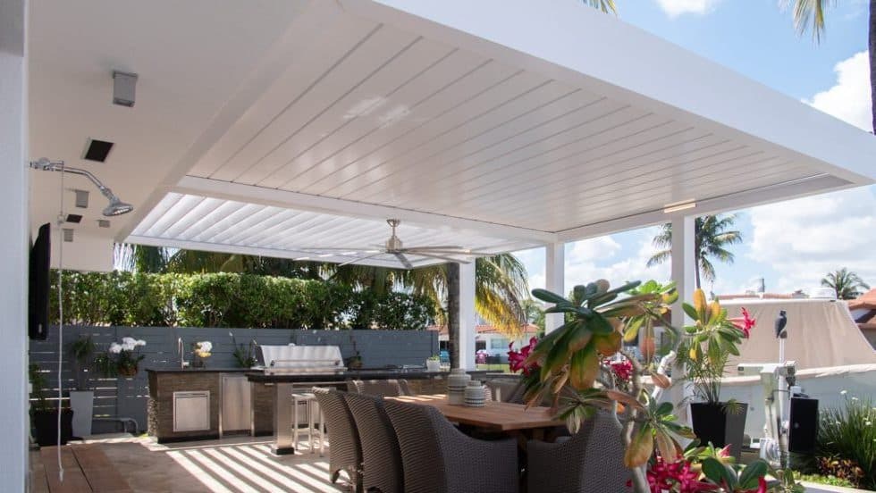 White louvered pergola shading a full outdoor kitchen