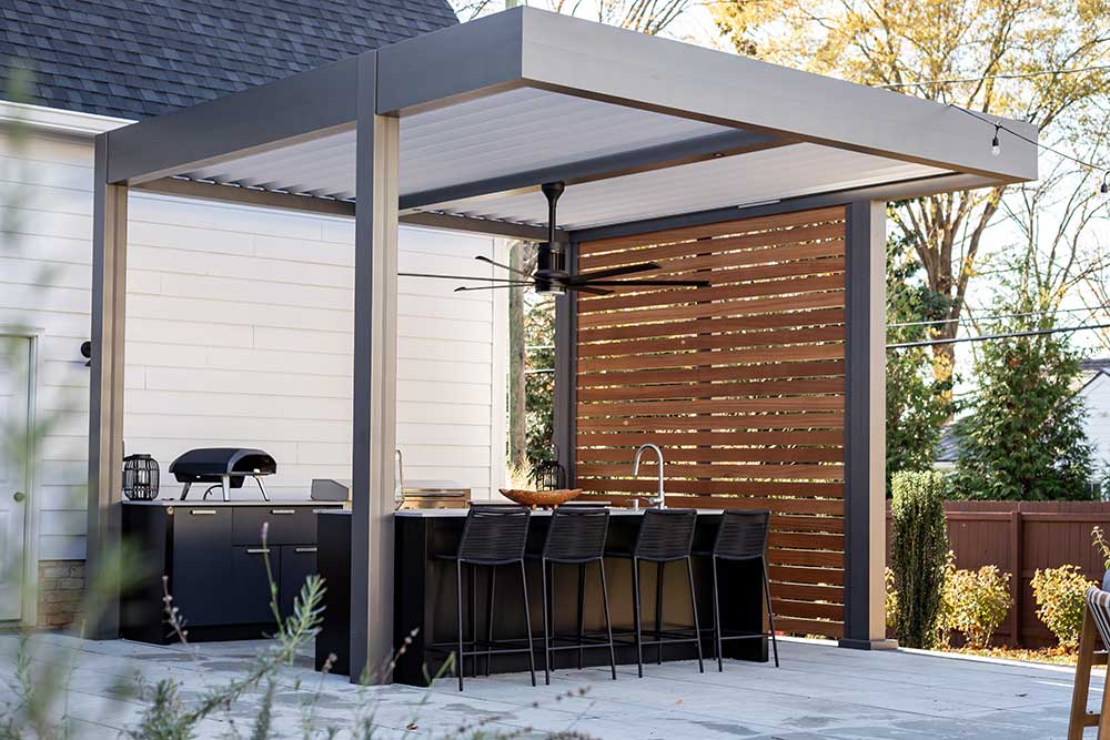Pergola over outdoor kitchen with privacy walls and recessed lighting