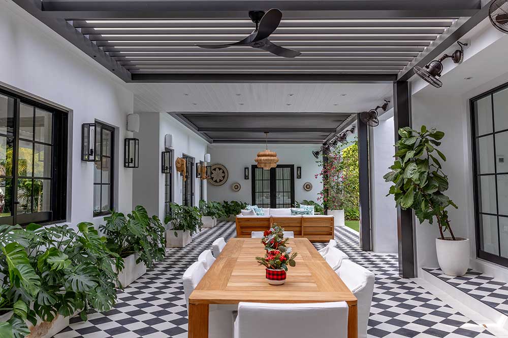 Gray bronze R-BLADE pergola with poolside seating and ceiling fans