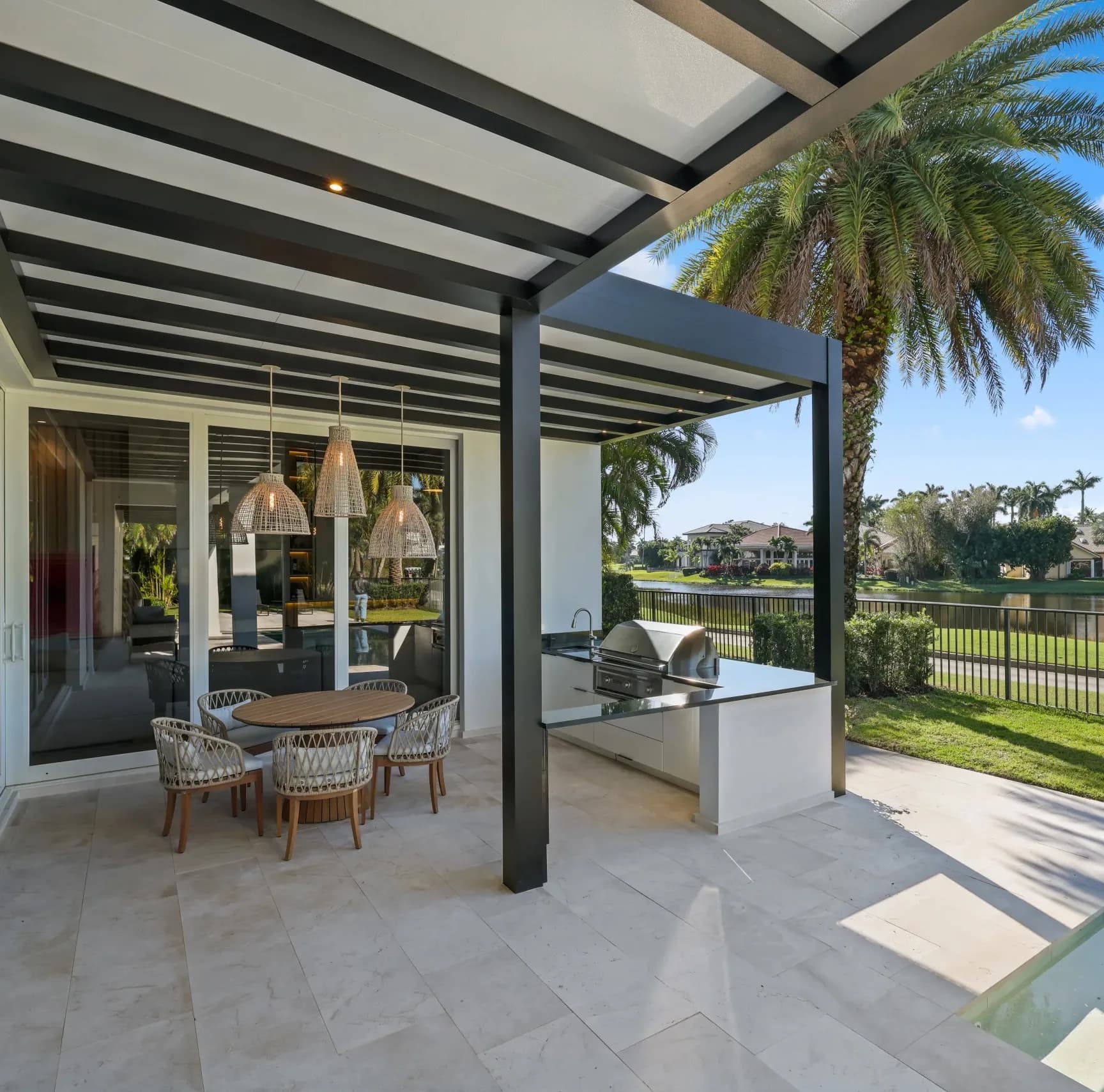 R-SHADE insulated patio cover with white roof panels over an outdoor kitchen and dining area