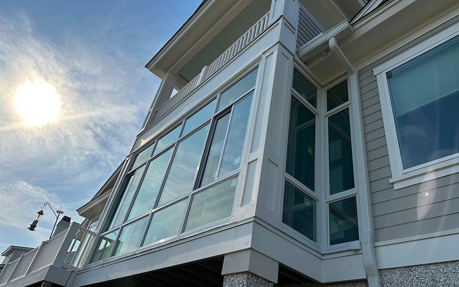 TEMO porch enclosure with white framed windows fitted beneath an existing covered upper porch