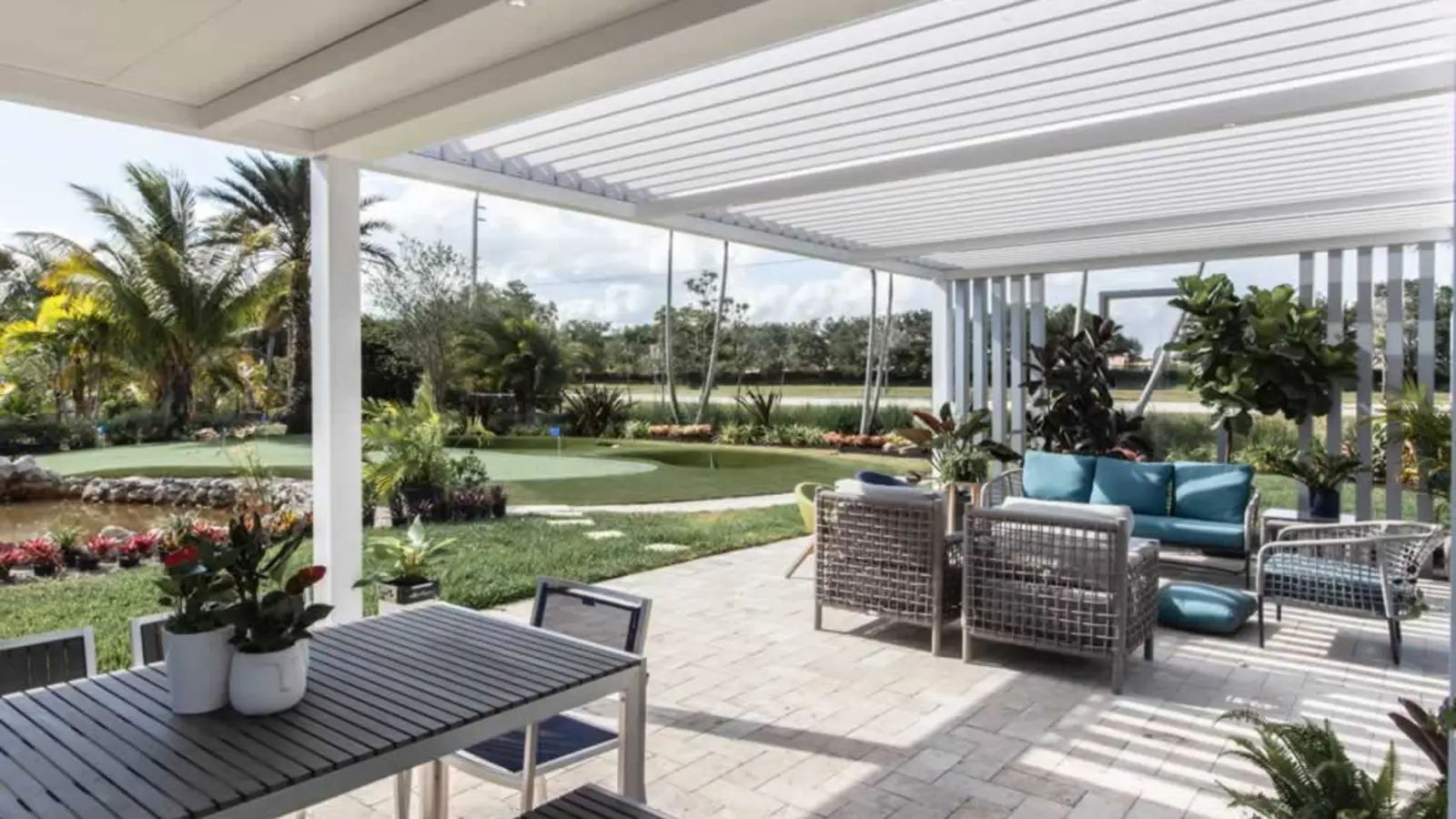 White aluminum patio cover with a fixed solid roof section beside a slatted louvered roof section